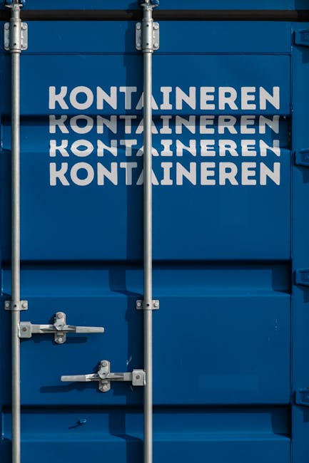 Detailed view of blue shipping container with text 'KONTAINEREN' and metal locks.